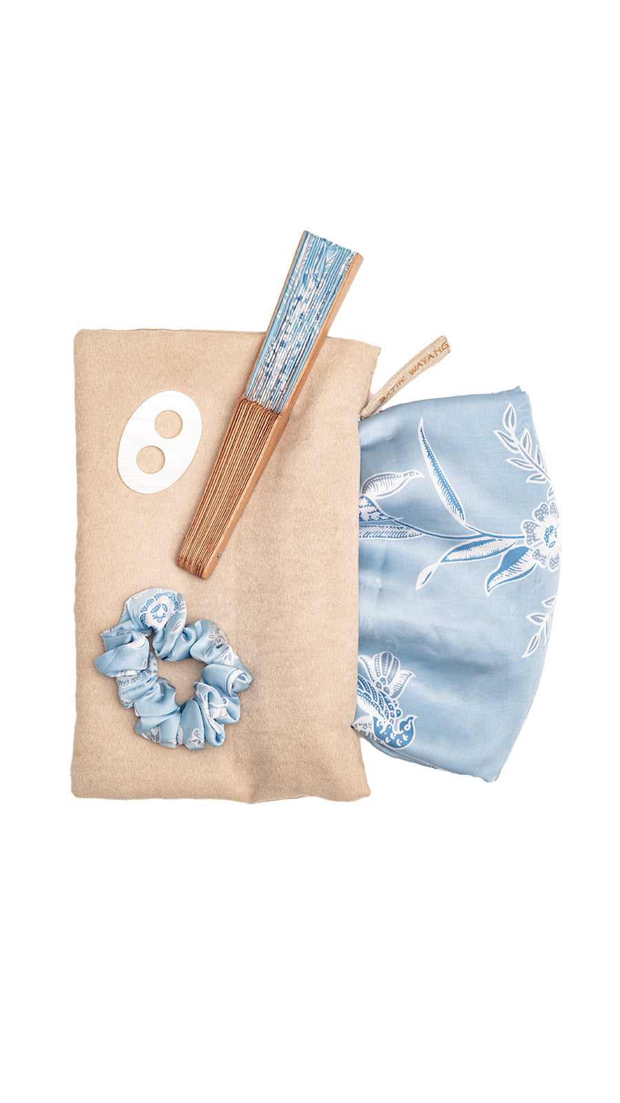 Set of beach set sarong and accessories including a scrunchie, white shell buckle and matching fan on a beige pouch with a white logo.