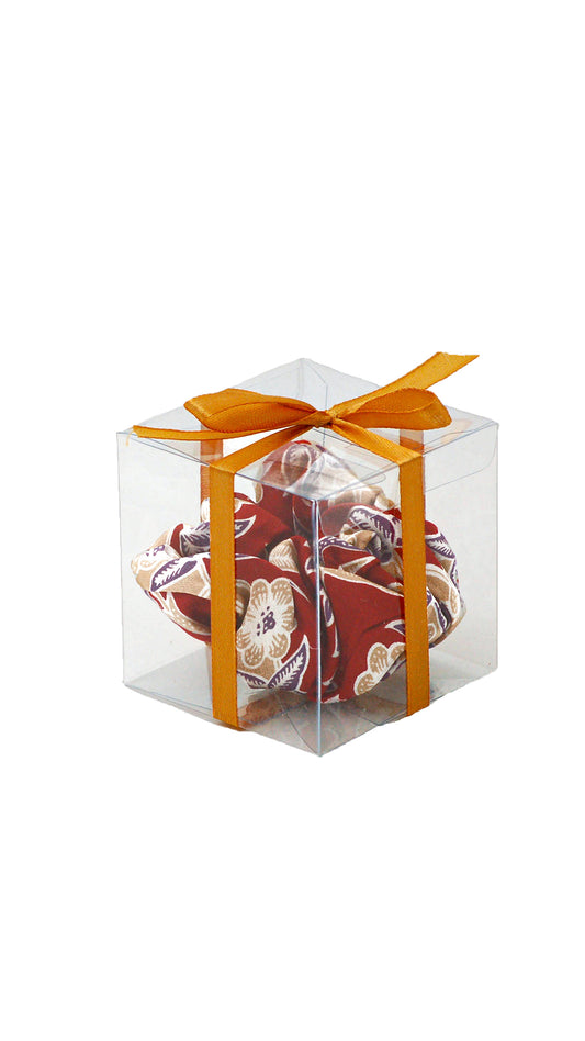 Clear gift box with a floral-patterned item and an orange ribbon on a white background